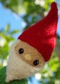 Lil Gnome peeks out from behind a tree.